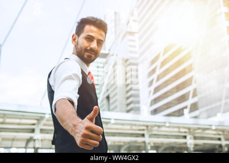 Business man good job thumb up hand showing outdoor office city background Stock Photo