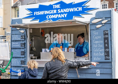 A mobile food seller advertising their speciality fish finger sandwiches amongst other tasty treats at the Great Yarmouth Maritime Festival Stock Photo