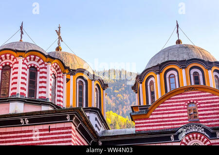Rila monastery, Bulgaria church domes and cross close-up and autumn mountain trees at background Stock Photo