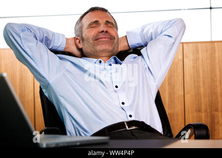 Smiling manager relaxing in office chair. Stock Photo