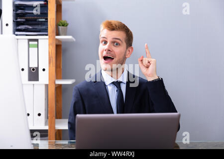 Businessman Having Ah Ha Moment While Working In Office On Laptop Stock Photo