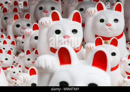 Gotoku ji Temple, Tokyo, Japan.  Maneki-Neko as a talismans have been left for an appreciation for the wishes granted by the visitors. Stock Photo