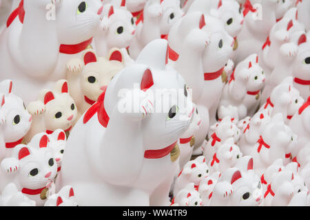 Gotoku ji Temple, Tokyo, Japan.  Maneki-Neko as a talismans have been left for an appreciation for the wishes granted by the visitors. Stock Photo