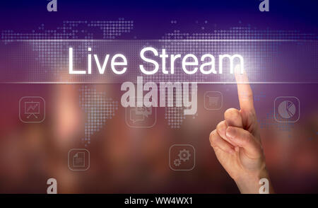 A hand selecting a Live Stream business concept on a clear screen with a colorful blurred background. Stock Photo