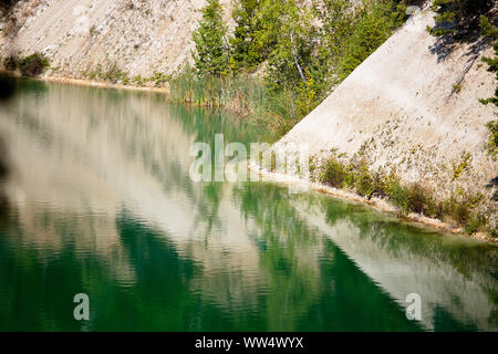 Deserted beach with clear turquoise rippled water on old lake formed on site of chalk quarry in Grodno Belarus in summer sunny day with copy space. Stock Photo