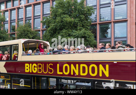 Bis Bus tour on an open top bus in London, with a tour guide speaking to tourists in the City of London, England, UK. Big Bus Tours London. Stock Photo