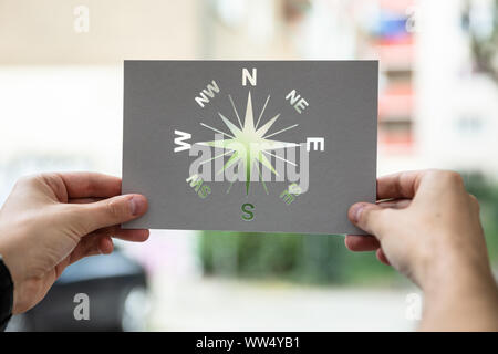 Hands Holding Paper With Cutout Compass Outdoors Stock Photo