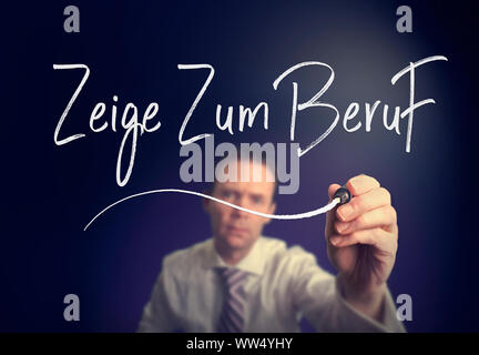 A businessman writing a Way To Work "Zeige Zum Beruf" concept in German with a white pen on a clear screen. Stock Photo
