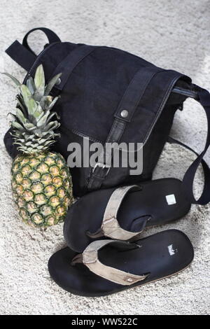 Shoulder bag, flip flops and a pineapple for the day on the beach or at the swimming pool,
