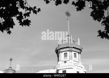 An old building with tower in Madrid which framed by leaves Stock Photo