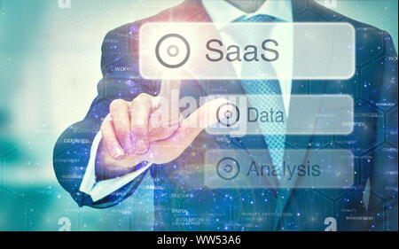 A business man selection a SaaS button on a futuristic display with a concept written on it. Stock Photo