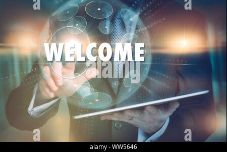A hand selecting a Welcome business concept on a futuristic computer display. Stock Photo