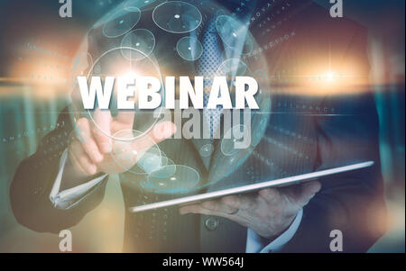 A hand selecting a Webinar business concept on a futuristic computer display. Stock Photo