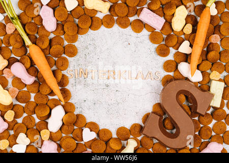 Dutch holiday Sinterklaas. Background with traditional food - pepernoten, chocolate letter, sweets strooigoed and carrots for horse. Concept for child Stock Photo