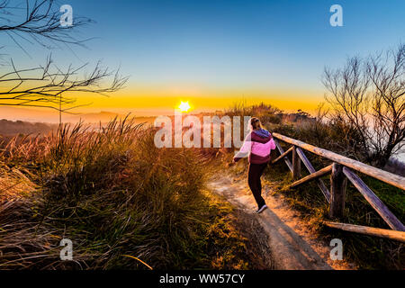 Woman walking along a footpath at sunset, Italy Stock Photo