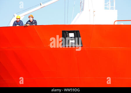 Red ship wall with workers, industrial harbour, ship, Bremen, Germany Stock Photo