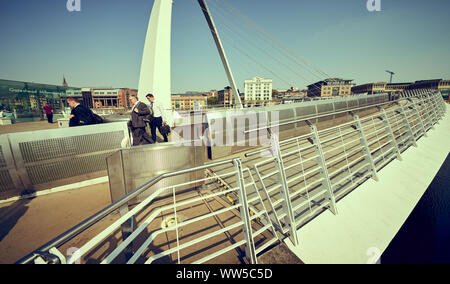 GATESHEAD, ENGLAND, UK - MAY 08, 2018: Commuters crossing the MIllennium Bridge on their way to work.