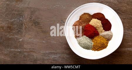 Different kind of spices in bowl for cooking on wooden background. Top view with copy space. Panorama, banner Stock Photo
