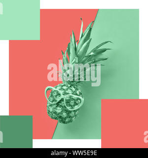 Trendy color matching complementary palette from pineapple in glasses on split paper background toned into neo mint and salmon colors Stock Photo