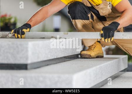 Construction Contractor Checking Stairs Levels Using Large Spirit Level Tool. Stock Photo