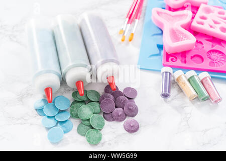 Flat lay. Ingredients to make chocolate mermaid molds from the chocolate chips. Stock Photo