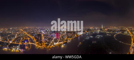 Ultra high resolution aerial panorama of Ho Chi Minh City or Saigon Vietnam under lights at night featuring all Landmark Buildings and Saigon River. Stock Photo