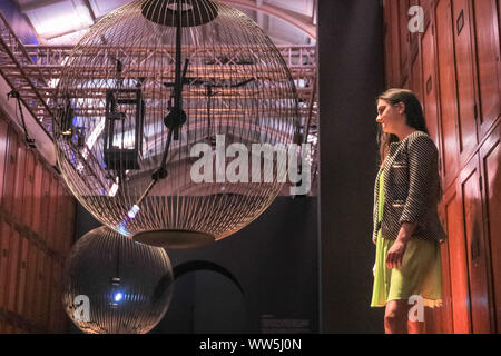 London, UK, 13th Sep 2019. An assistant engages with 'Affinity in Autonomy', an interactive installation by Sony Designs which looks at the future of AI and allows visitors to engage with a robotic pendulum. London Design Festival runs from 14-22 September 2019. Credit: Imageplotter/Alamy Live News Stock Photo