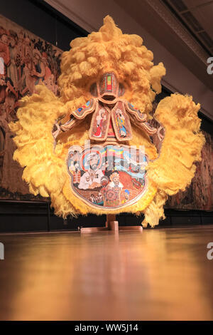 London, UK, 13th Sep 2019. An assistant poses with the colourful 'Black Masking Culture' artist and educator Big Chief Demond Melancon of the Young Seminole Hunters huge exhibits of Mardi Gras Indian suits. London Design Festival runs from 14-22 September 2019. Credit: Imageplotter/Alamy Live News Stock Photo