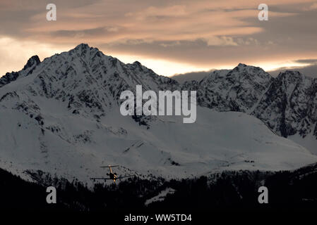 An airplane landing during afterglow on the Innsbruck airport in front of the Nockspitze, also called Saile. Stock Photo
