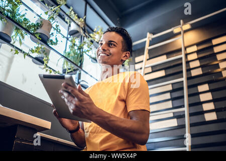 Man using his tablet in a coffee shop. Stock Photo