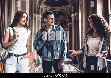 It 's Real emotions. Three Beautiful students are walking in the university ,chatting and smiling. Stock Photo