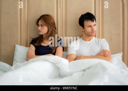 Unhappy couple not talking after an argument in bed at home. People, relationship difficulties and family concept Stock Photo