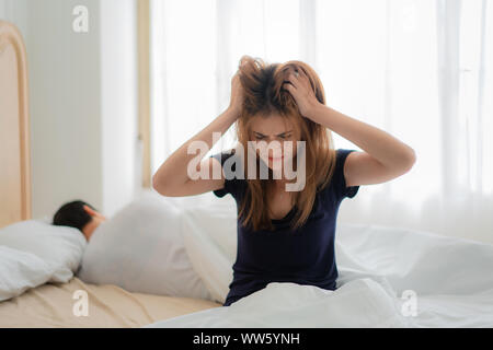Unhappy couple not talking after an argument in bed at home. People, relationship difficulties and family concept Stock Photo