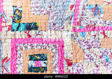 textile background - surface of patchwork scarf stitched from various silk strips and crushed pink cotton fabric Stock Photo