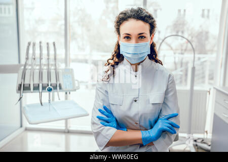 Portrait of female dentist. She standing at her office in mask. Stock Photo
