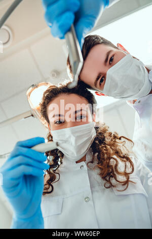 Patient from the dental chair view of the dentist and assistant. Bottom view. Stock Photo