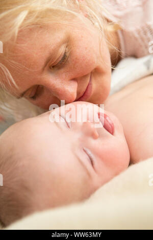 Mother with sleeping baby in bed, detail Stock Photo
