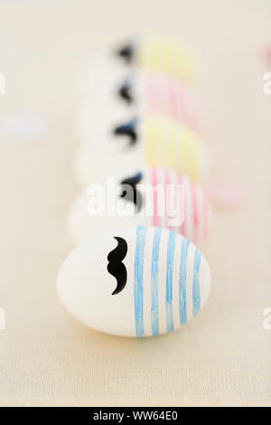 Line-up, row of Easter eggs with beard, colourful Stock Photo
