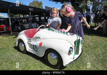 Poppy, six (right), and her sister Milly, three, from Gloucestershire, polish their Austin J40 pedal car ahead of Saturday's Settrington Cup, during day one of the Goodwood Revival at the Goodwood Motor Circuit, in Chichester. Stock Photo