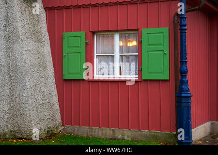 Red house, window with with green shutters, illuminated Stock Photo