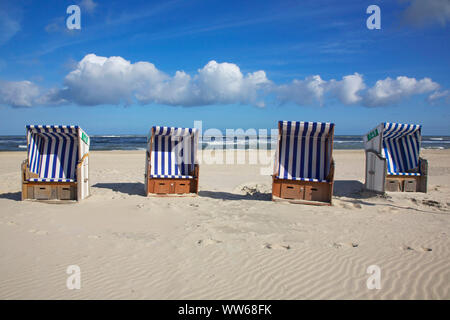 Beach chairs at the white dune on the north beach of the island Norderney. Stock Photo