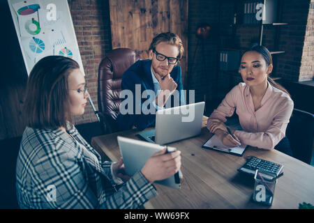 Three nice chic busy stylish elegant business sharks discussing showing presenting strategy profit growth development appointment at industrial loft Stock Photo