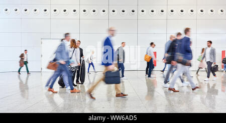 Many anonymous business people go by going to a trade fair Stock Photo