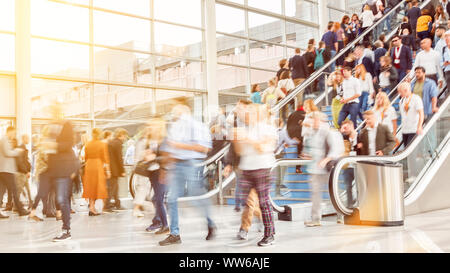 Many anonymous people in full shopping center on escalators Stock Photo