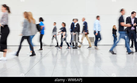 Many anonymous business people go to a business trade fair Stock Photo