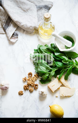 Basil pesto ingredients on marble background. Top view composition, recipe flatlay Stock Photo