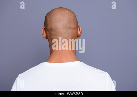 Close up back behind rear view photo dark skin he him his man turned to empty space distracted unrecognizable groomed shaved head wearing white t Stock Photo