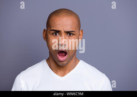 Close-up portrait of nice handsome attractive guy wearing white shirt opened mouth isolated over gray pastel background Stock Photo