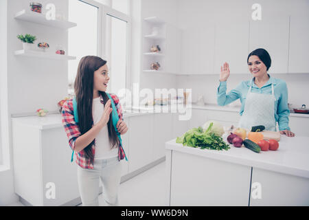 Portrait of two nice cute lovable adorable sweet attractive cheerful positive people mature kind careful mum waving to pre-teen girl in light white Stock Photo