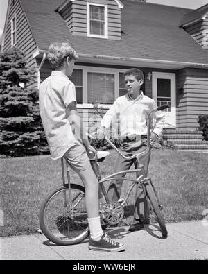 1960s 1970s TWO PRETEEN BOYS ONE AFRICAN AMERICAN AND THE OTHER CAUCASIAN WITH BICYCLE TALKING TOGETHER ON SUBURBAN SIDEWALK - b23982 HAR001 HARS RACIAL MALES TEENAGE BOY BICYCLES TRANSPORTATION B&W BIKES NEIGHBORS NEIGHBORHOOD AFRICAN-AMERICANS AFRICAN-AMERICAN AND BLACK ETHNICITY FRIENDLY RACE RELATIONS JUVENILES PRE-TEEN PRE-TEEN BOY BLACK AND WHITE BUDDIES CAUCASIAN ETHNICITY HAR001 OLD FASHIONED AFRICAN AMERICANS Stock Photo